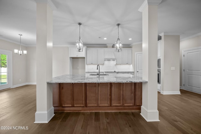 kitchen featuring a sink, dark wood-type flooring, backsplash, white cabinetry, and crown molding