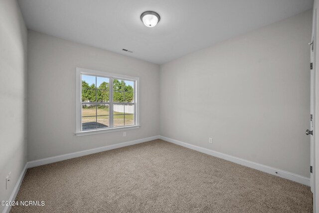 empty room featuring carpet floors and baseboards