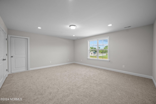 carpeted spare room featuring baseboards and recessed lighting