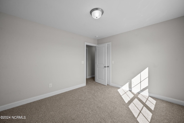 unfurnished room featuring carpet flooring and baseboards