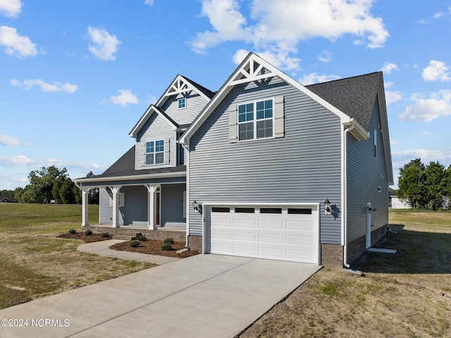 view of front of property featuring a porch, a front yard, concrete driveway, and a garage