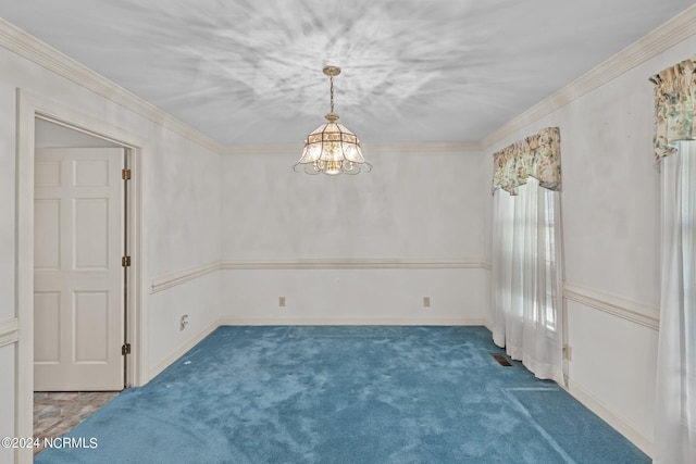 spare room featuring dark colored carpet, crown molding, and a notable chandelier