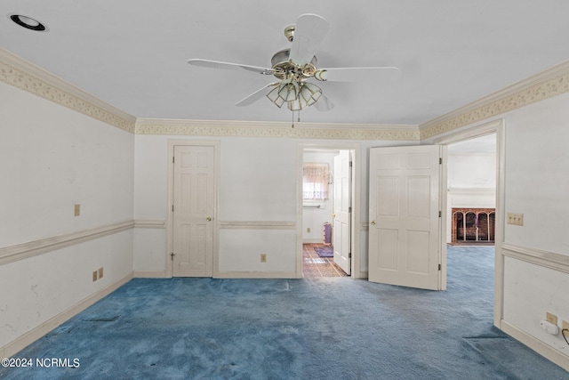 carpeted spare room with ceiling fan and ornamental molding