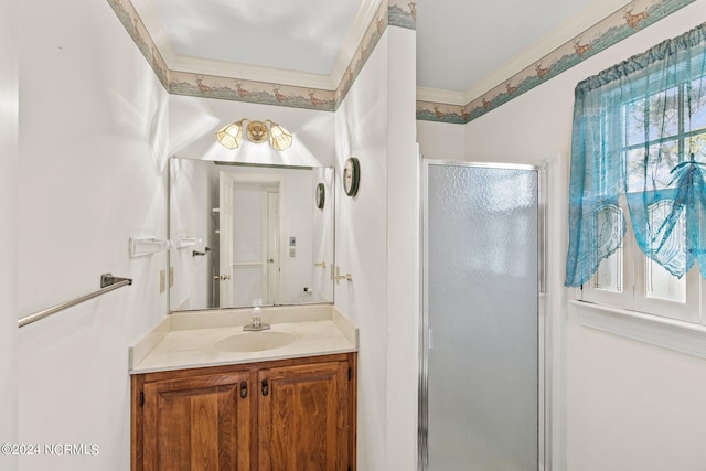 bathroom featuring vanity, a shower with door, and ornamental molding