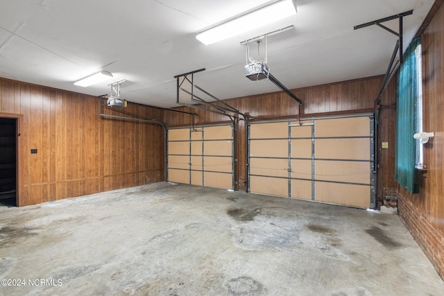 garage with a garage door opener and wooden walls