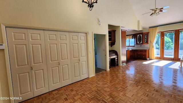 unfurnished living room featuring parquet floors, high vaulted ceiling, and ceiling fan