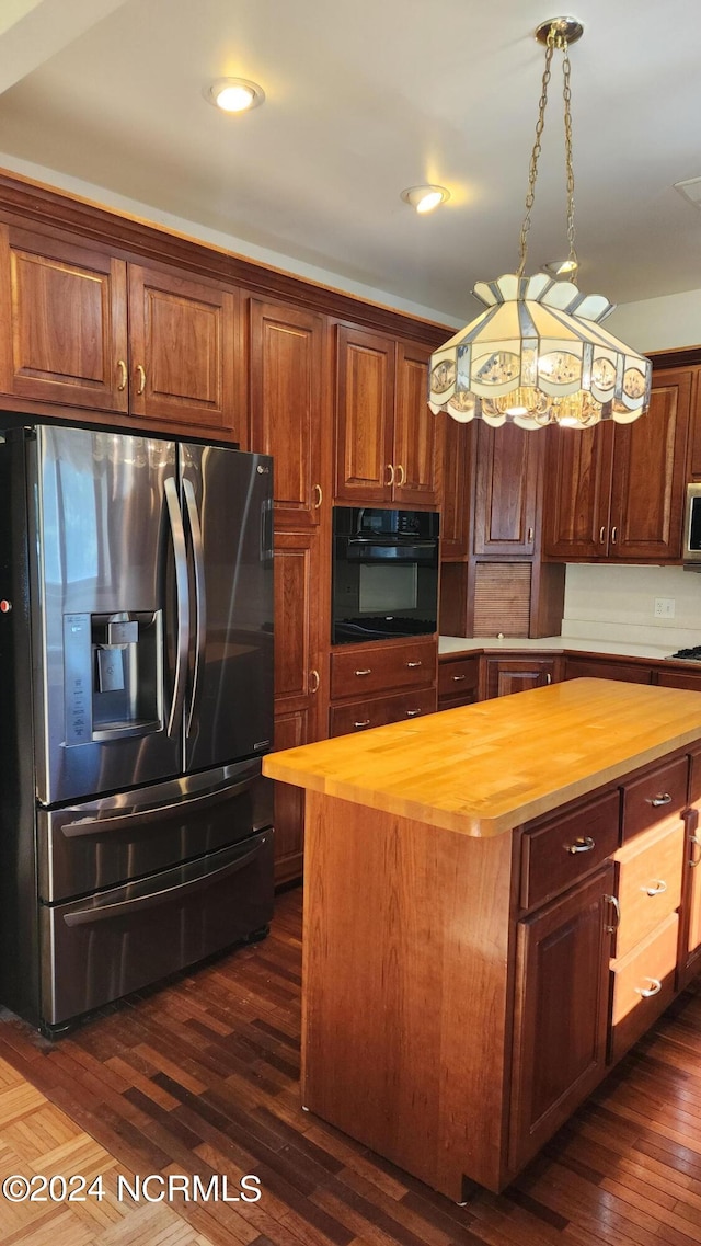 kitchen featuring appliances with stainless steel finishes, dark hardwood / wood-style flooring, butcher block counters, and a kitchen island