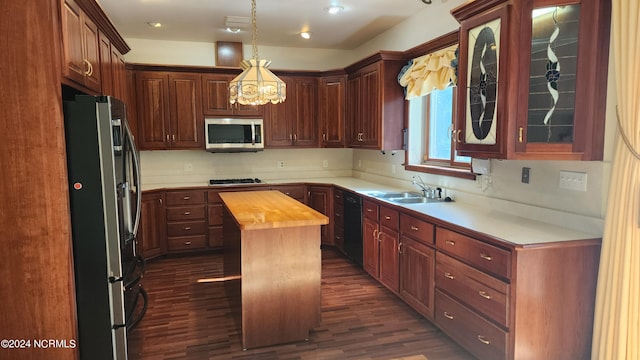 kitchen with dark hardwood / wood-style flooring, a center island, wooden counters, appliances with stainless steel finishes, and sink