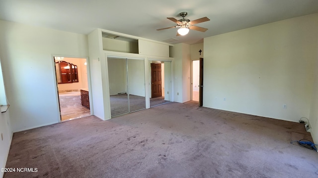 unfurnished bedroom featuring a closet, ceiling fan, carpet floors, and ensuite bathroom