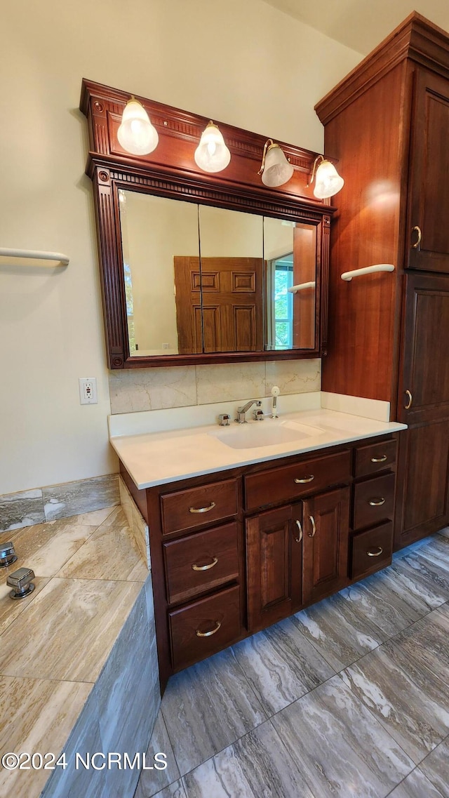 bathroom with tile flooring, vanity, and tasteful backsplash