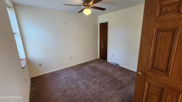 empty room featuring dark carpet and ceiling fan