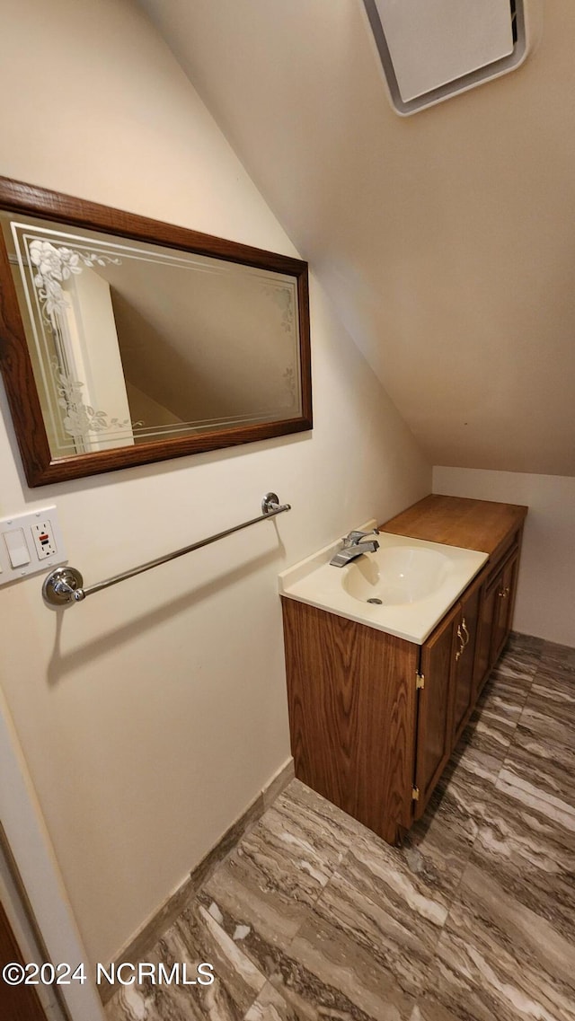 bathroom with vaulted ceiling, hardwood / wood-style flooring, and vanity