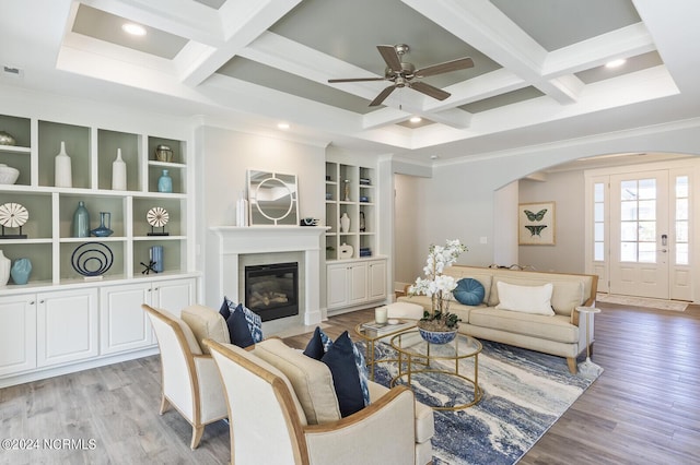 living room featuring beamed ceiling, coffered ceiling, and light hardwood / wood-style flooring