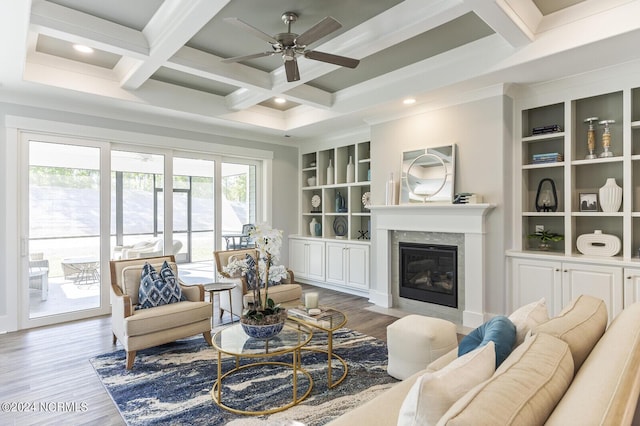 living room with a fireplace, hardwood / wood-style flooring, coffered ceiling, beam ceiling, and built in shelves