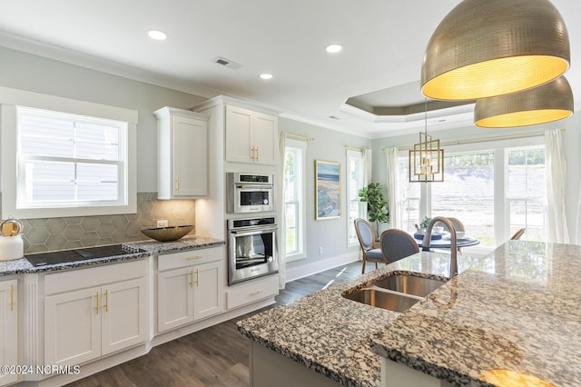 kitchen featuring black electric stovetop, light stone countertops, sink, and white cabinets