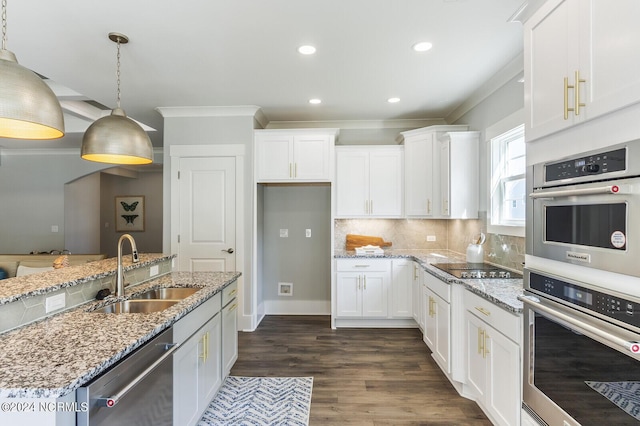 kitchen featuring decorative light fixtures, sink, white cabinets, stainless steel appliances, and light stone countertops