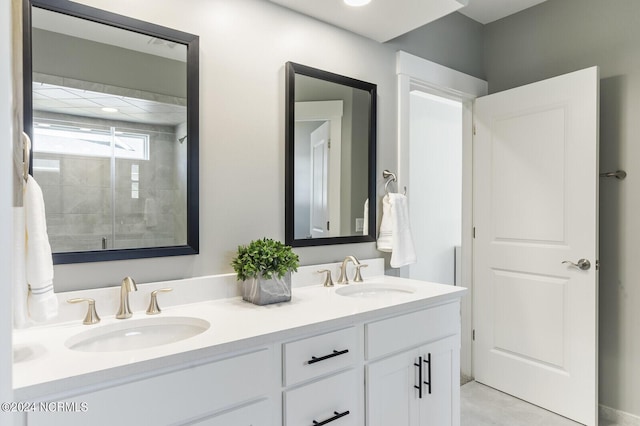 bathroom featuring a sink, double vanity, and tiled shower