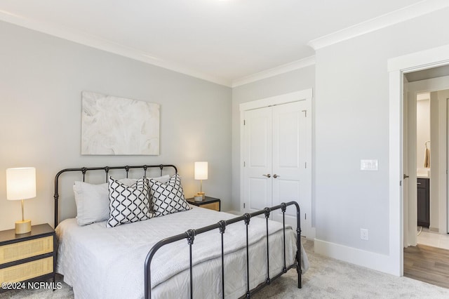 carpeted bedroom with crown molding and a closet