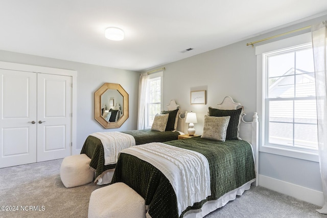 carpeted bedroom with baseboards, visible vents, and a closet
