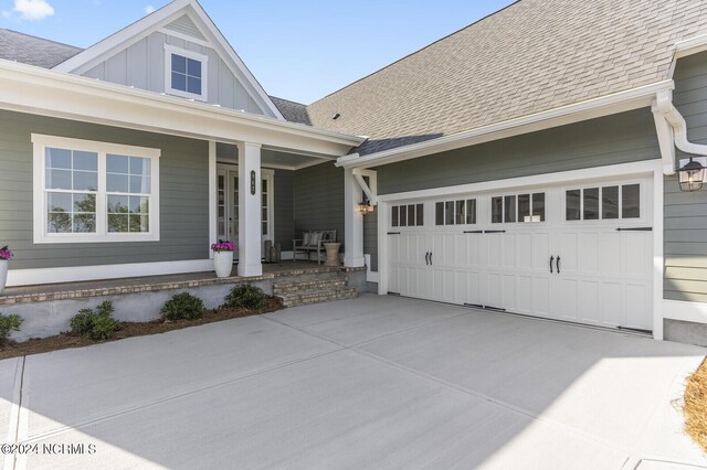 view of front facade with a front yard, a porch, and a garage