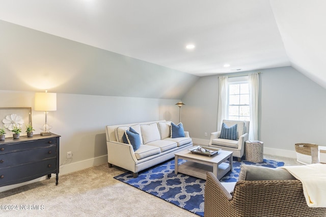 carpeted living room featuring lofted ceiling and baseboards