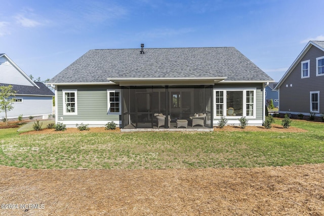 rear view of property with a lawn, a shingled roof, and a sunroom