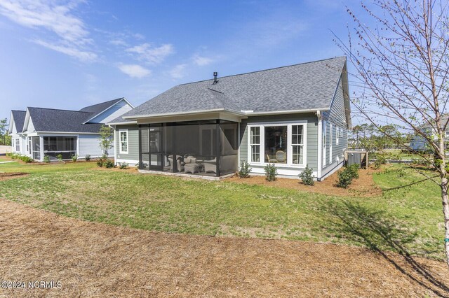 rear view of property with a sunroom, a yard, and central air condition unit