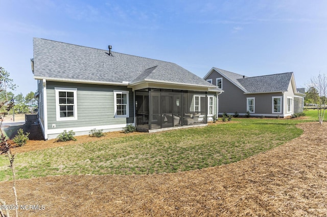 back of property with a sunroom, a yard, and roof with shingles