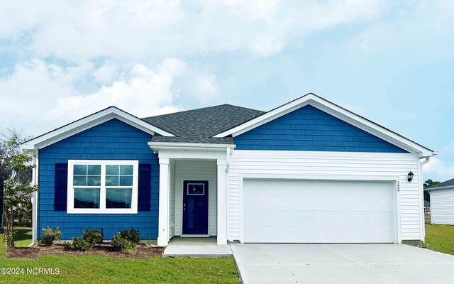 single story home featuring a shingled roof, driveway, and an attached garage