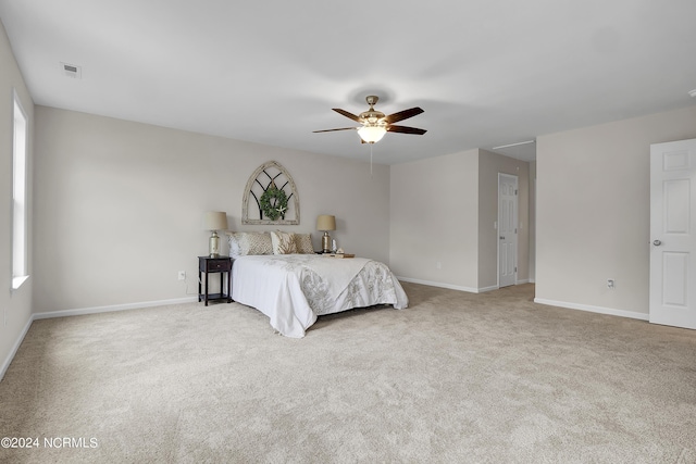 unfurnished bedroom with multiple windows, light carpet, and ceiling fan