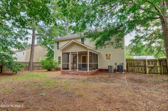 rear view of house featuring a sunroom and central air condition unit