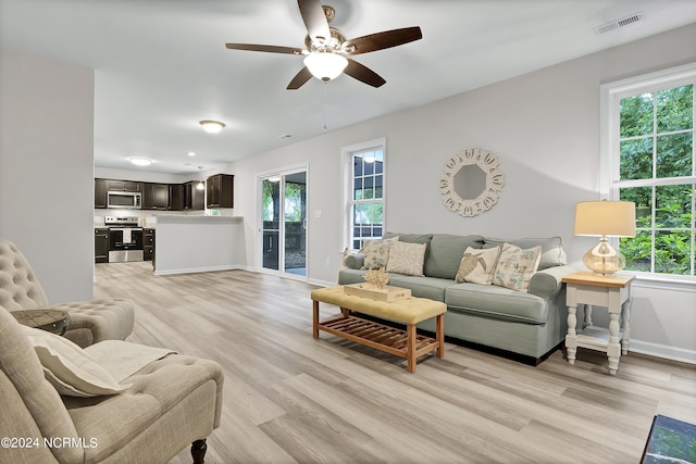 living room featuring ceiling fan and light hardwood / wood-style flooring