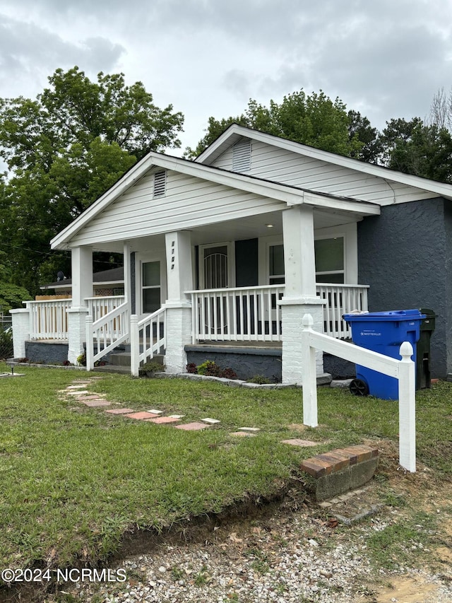 view of front of property featuring a porch and a front yard