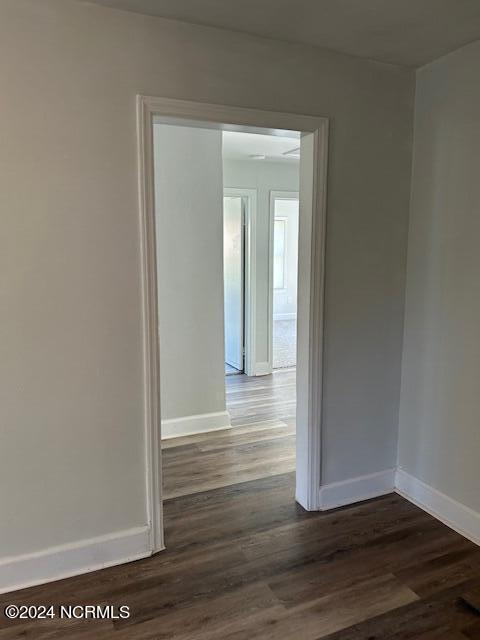 spare room with dark wood-style floors and baseboards