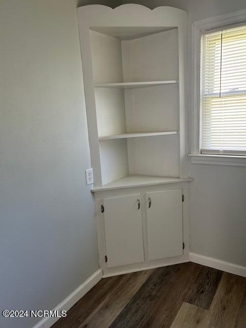 interior space with dark wood-style flooring and baseboards