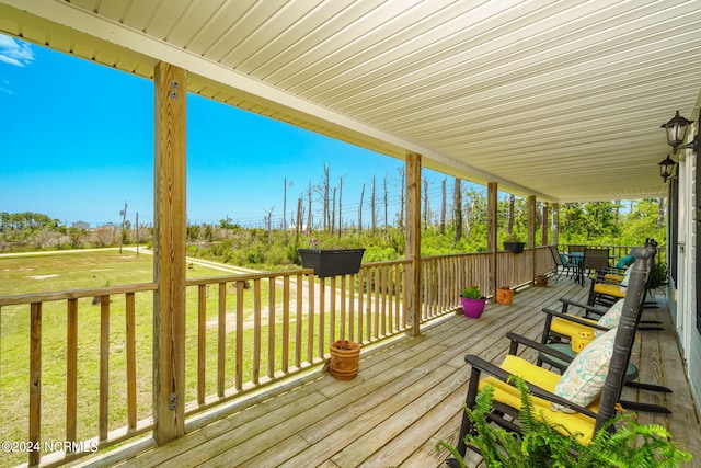 wooden deck featuring a lawn