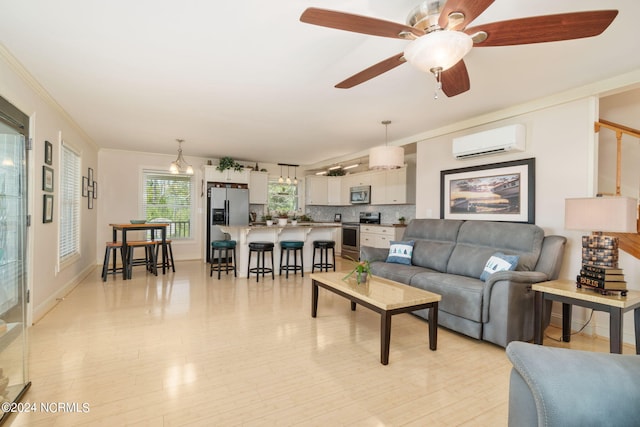 living room with ceiling fan, crown molding, light hardwood / wood-style floors, and a wall mounted AC