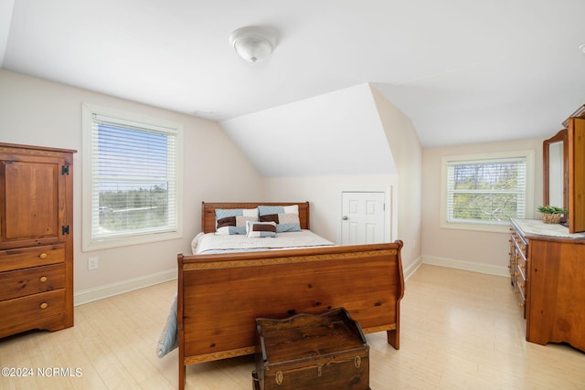 bedroom with vaulted ceiling and light hardwood / wood-style flooring