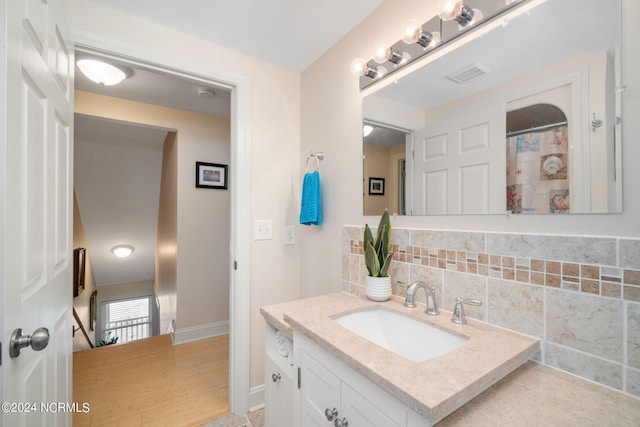 bathroom featuring vanity and decorative backsplash