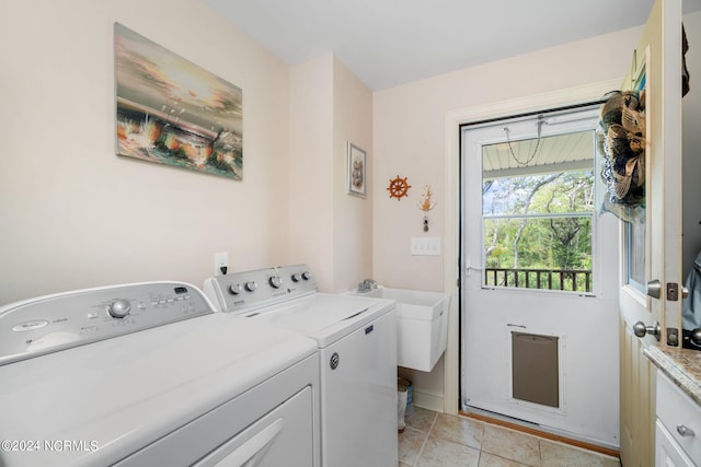 laundry area featuring cabinets, separate washer and dryer, sink, and light tile patterned floors