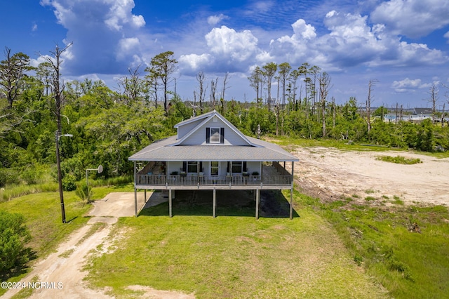 rear view of house featuring a yard and covered porch