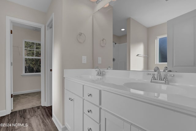 bathroom featuring vanity, wood-type flooring, and a shower