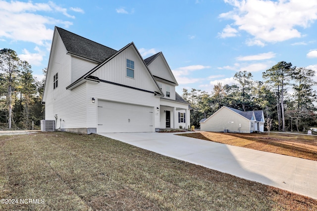 view of front facade featuring central air condition unit, a front lawn, and a garage