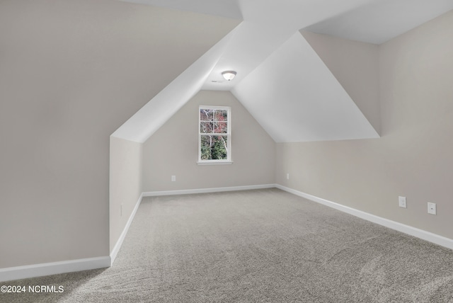 bonus room with vaulted ceiling and carpet