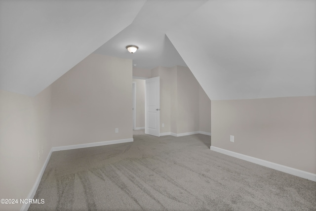 additional living space with light carpet and lofted ceiling