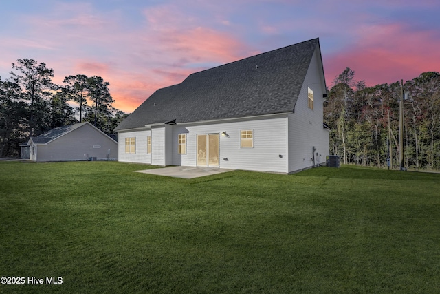 189 Vista Cay Dr, Hubert, NC 28539 - back of house at dusk featuring a yard, roof with shingles, central air condition unit, and a patio area