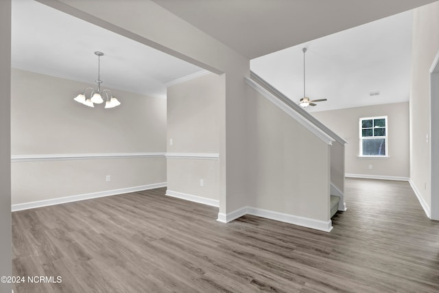 interior space featuring crown molding, ceiling fan with notable chandelier, and hardwood / wood-style floors