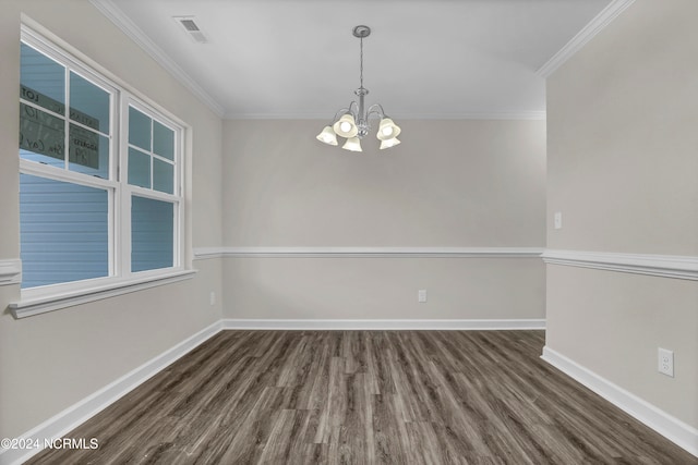 spare room featuring dark wood-type flooring, crown molding, and an inviting chandelier