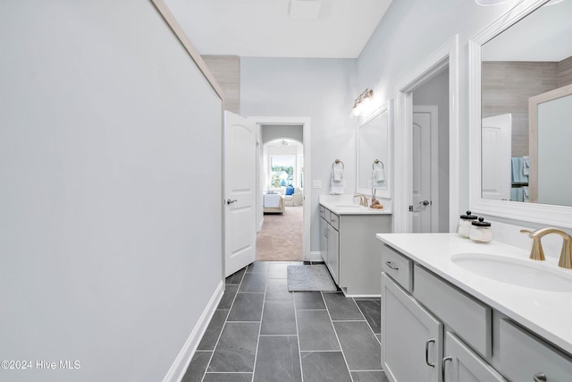 bathroom featuring two vanities, a sink, tile patterned flooring, and baseboards