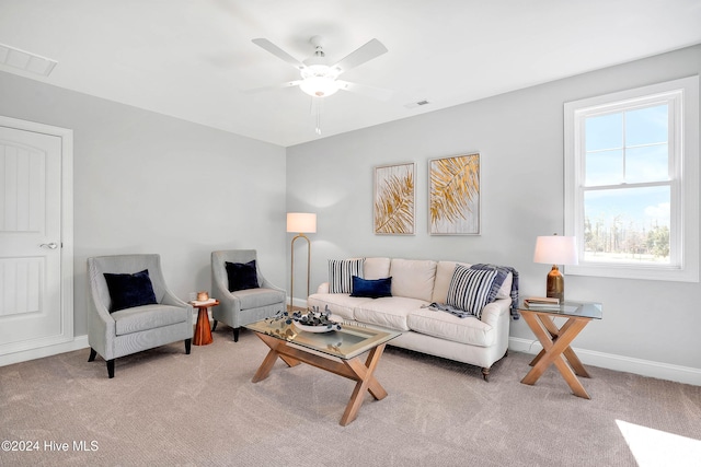 carpeted living room with ceiling fan